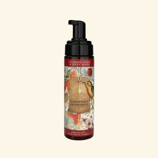 Foaming hand and body wash bottle with decorative label on a beige background