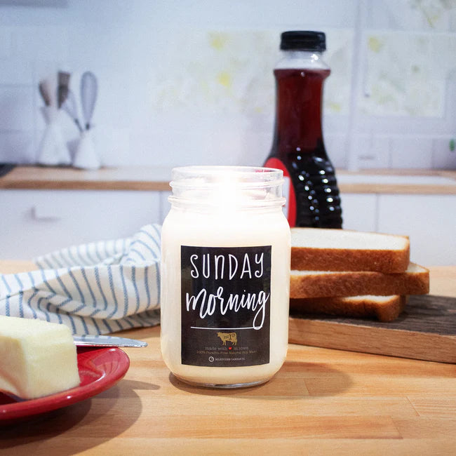 Jar of cream with 'Sunday Morning' label on a kitchen counter with bread and butter.