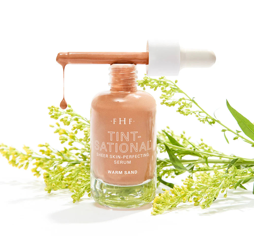 FHF Tint-Sational serum bottle with dropper on a white background with green leaves.