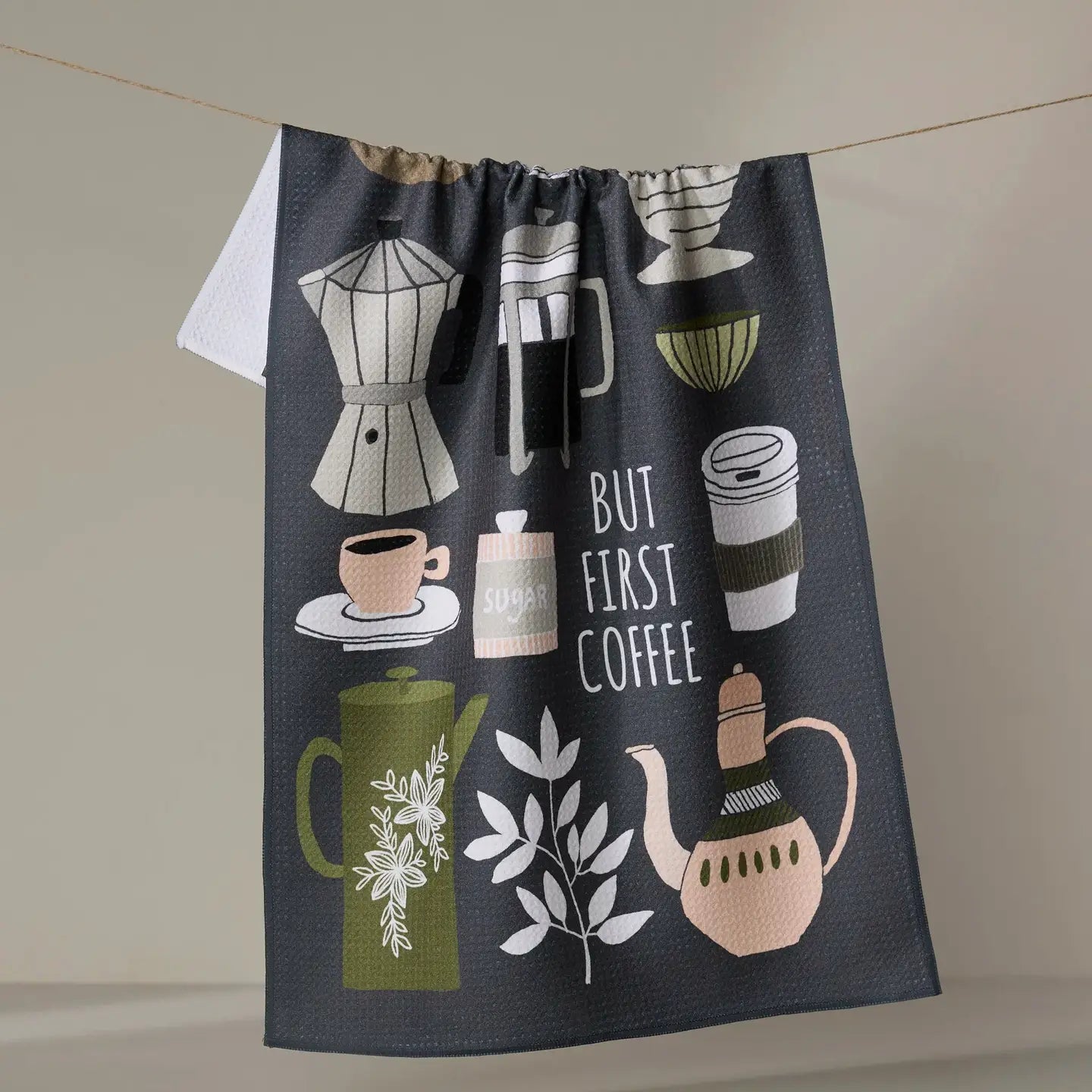 Black Geometry tea towel with coffee-themed illustrations hanging on a line.