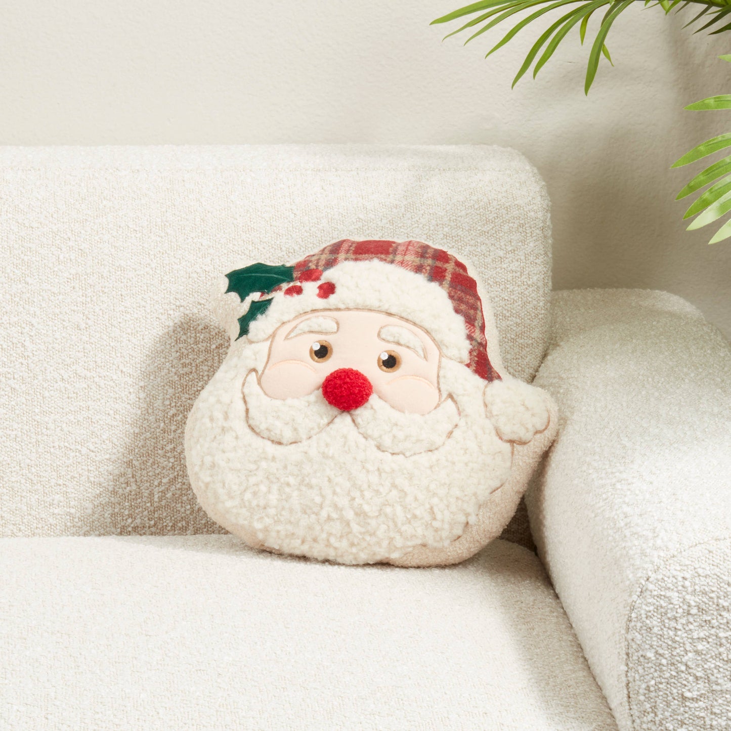 Plush Santa Claus pillow on a white surface with a neutral background