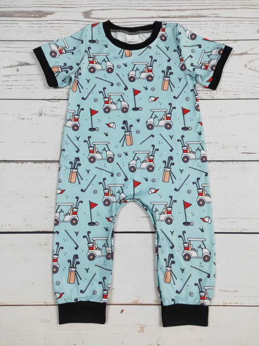 Children's onesie with golf-themed pattern on a wooden surface