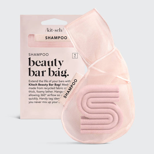 A blush pink mesh fabric shampoo beauty bar bag with a transparent window displaying the product. It is packaged with a product card that has text including the brand name and product description.
