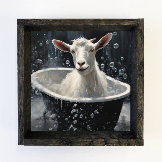 Framed artwork of a goat taking a bath with bubbles.