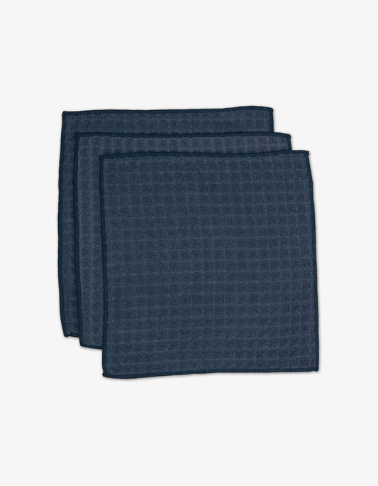 Geometry Waffle Washcloth Set Three dark blue textured napkins stacked on a white background