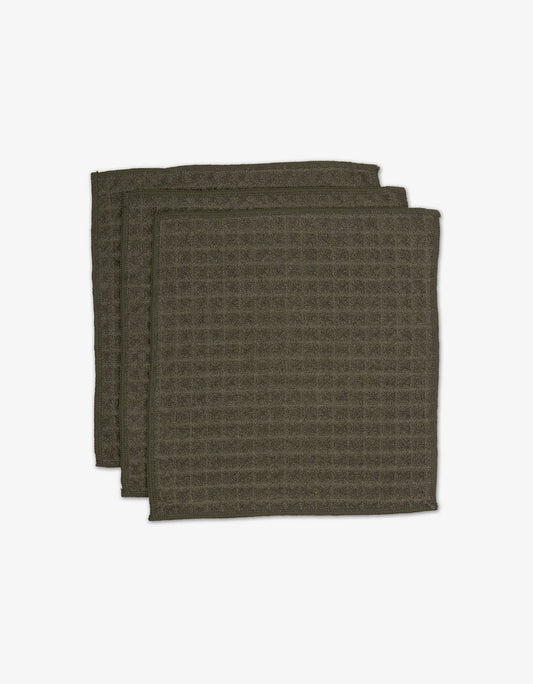A set of dark green waffle washcloths stacked on top of each other.