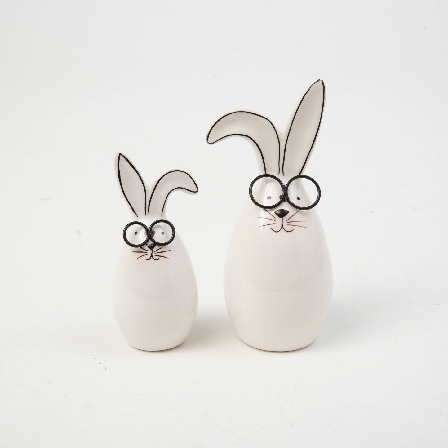 Two ceramic bunny figures with googly eyes on a white background