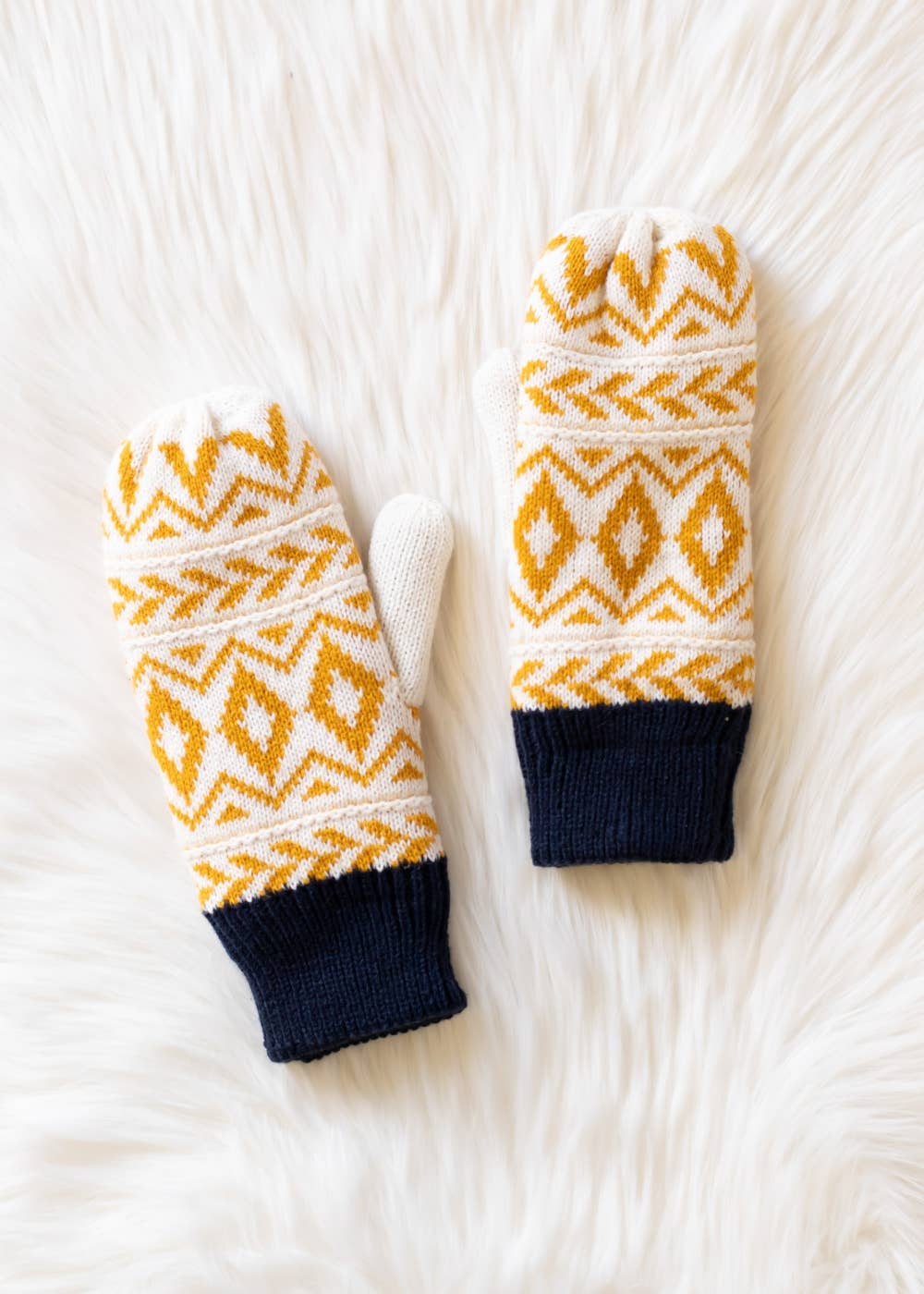 Pair of mittens with yellow pattern on a white textured background