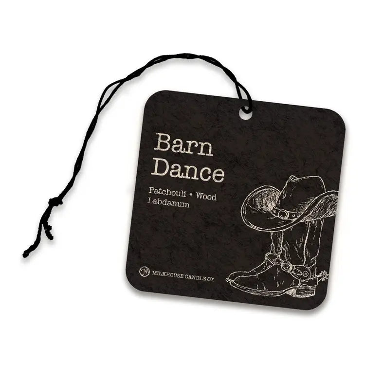 A square black car air freshener tag with a black hanging string, featuring the scent name 'Barn Dance' and a white sketch of cowboy boots and a hat on a white background.