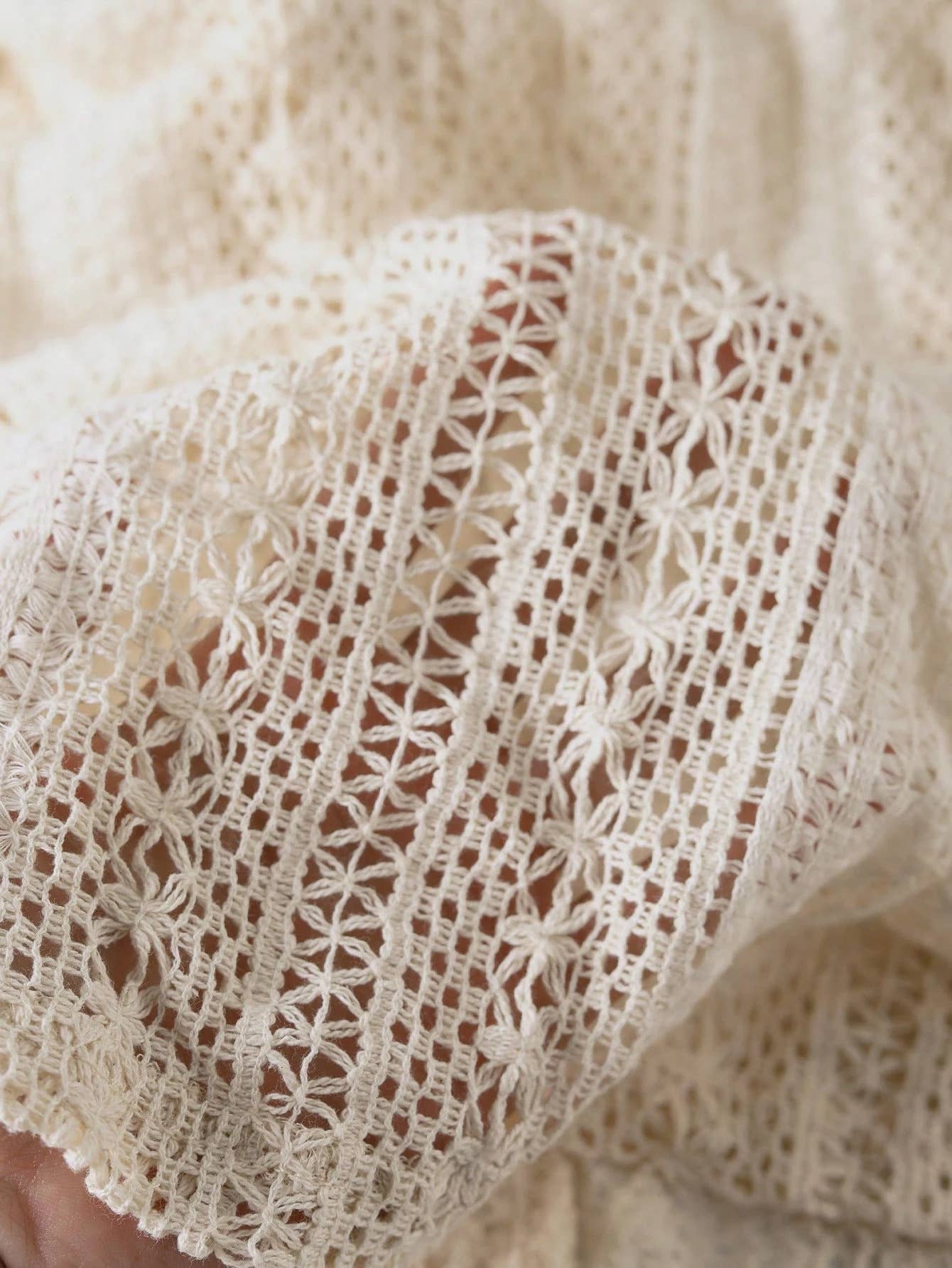 Close-up of beige lace fabric with intricate patterns