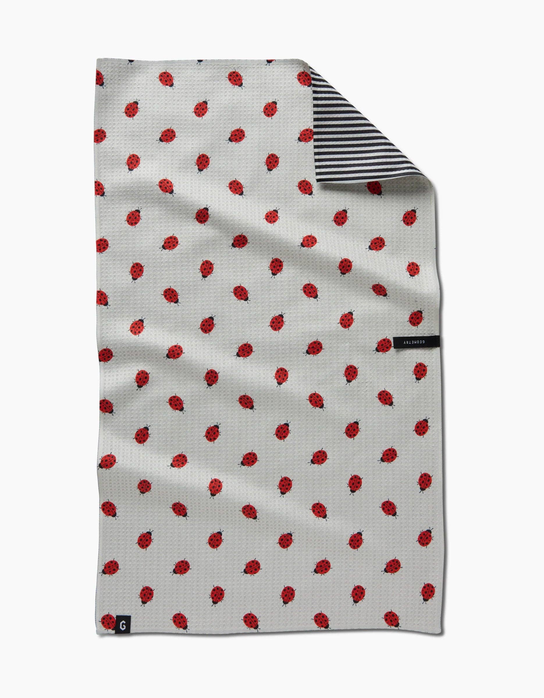 White towel with red pattern and black and white striped border on a white background