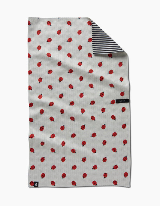 White towel with red pattern and black and white striped border on a white background