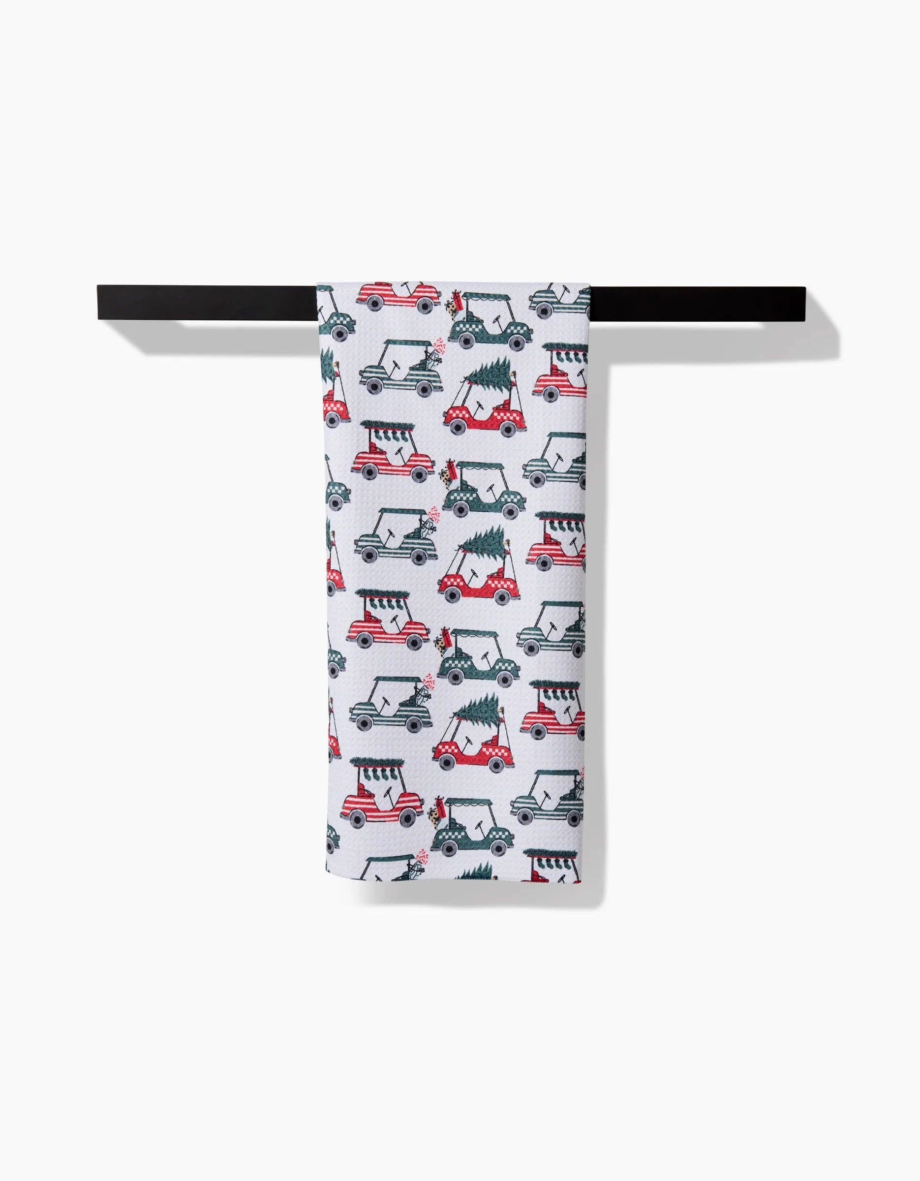 Geometry Tea Towel with Christmas-themed vehicle pattern hanging on a black rack against a white background