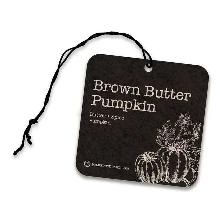 A square air freshner tag with rounded corners, featuring the scent name 'Brown Butter Pumpkin' in white text, smaller 'Butter • Spice Pumpkin' text, white pumpkin line art, and a black hanging string. The tag is photographed on a clean white background.