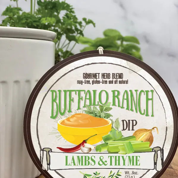 Label for Buffalo Ranch Dip by Lambs & Thyme on a marble surface with herbs in the background.