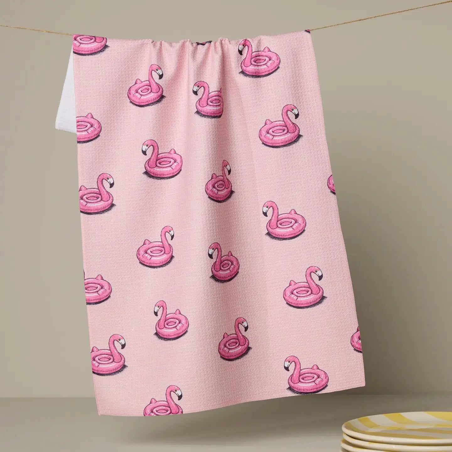 Pink Geometry Tea towel with inflatable flamingo pattern on a beige background