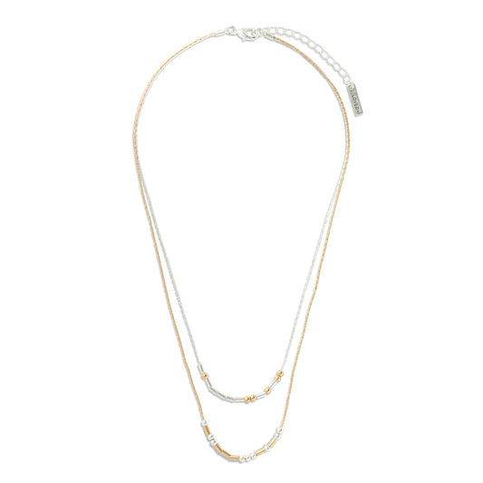 Two gold necklaces on a white background, beads spell out you are loved in morse code