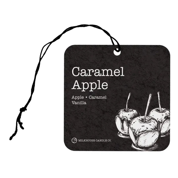 A square black car air freshener tag with rounded corners, featuring a black string loop at the top. The tag has a textured dark background with white text reading 'Caramel Apple' and 'Apple • Caramel • Vanilla', plus a white line-art illustration of three caramel apples.