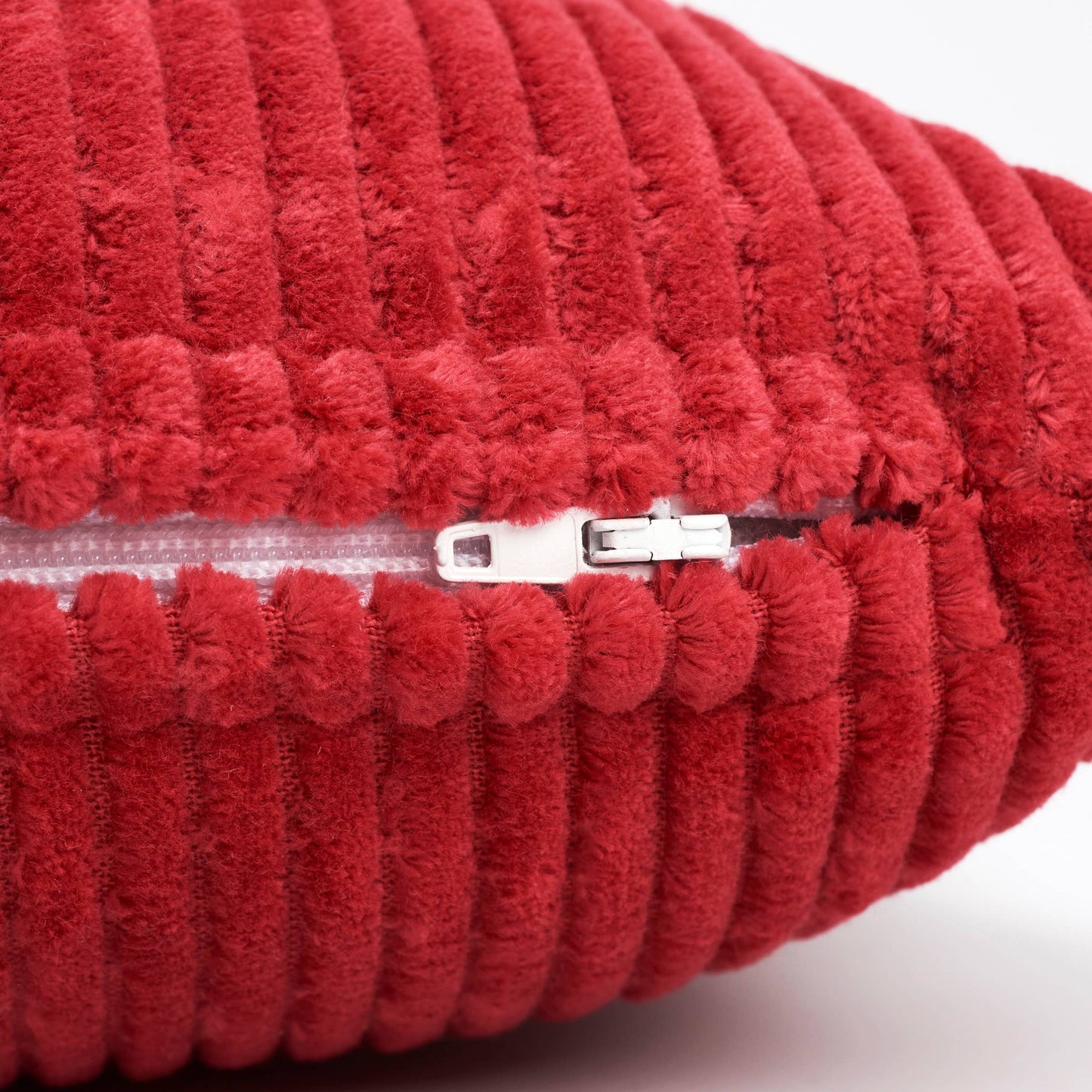 Red textured pillow with a zipper on a white background