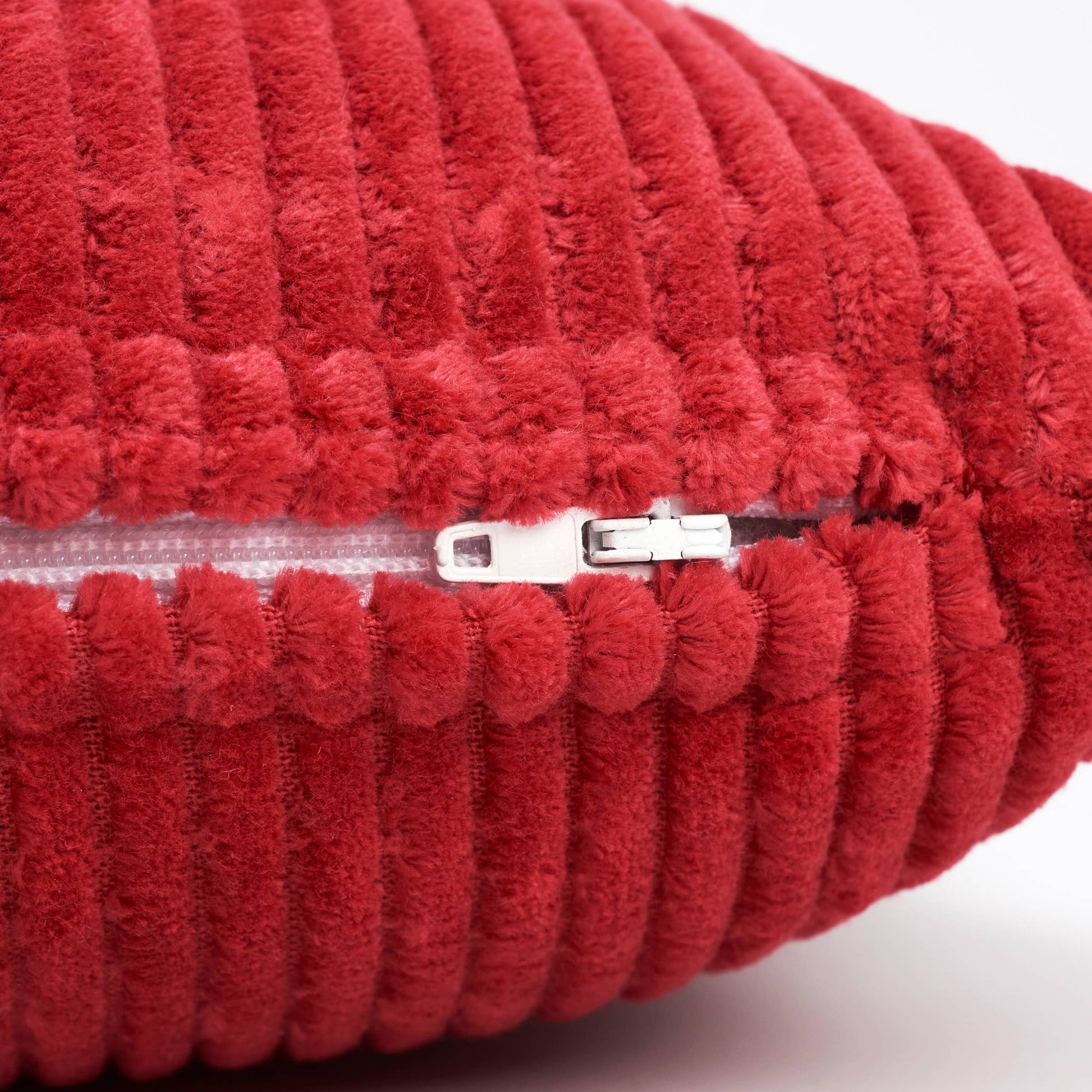 Red textured pillow with a zipper on a white background