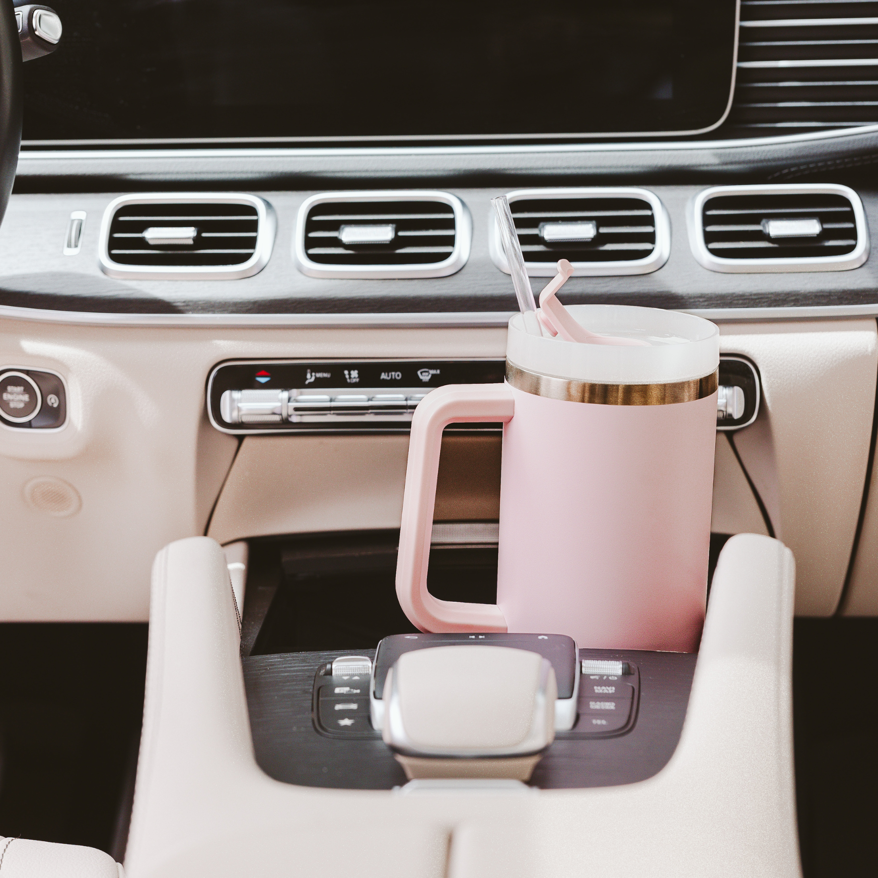 Pink mug with straw in a car cup holder