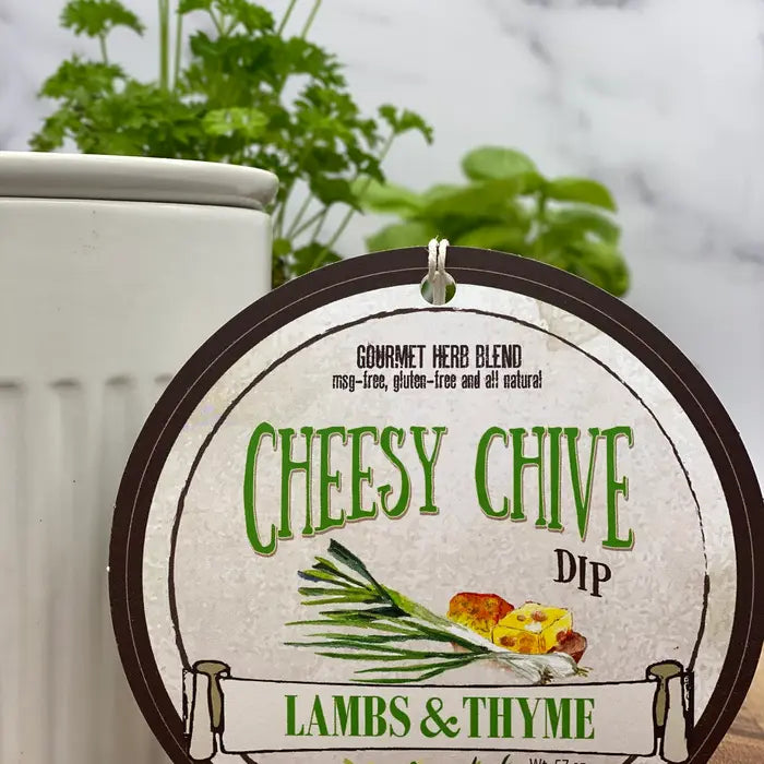 Cheesy Chive Dip container from Lambs & Thyme with herbs and text on a white background