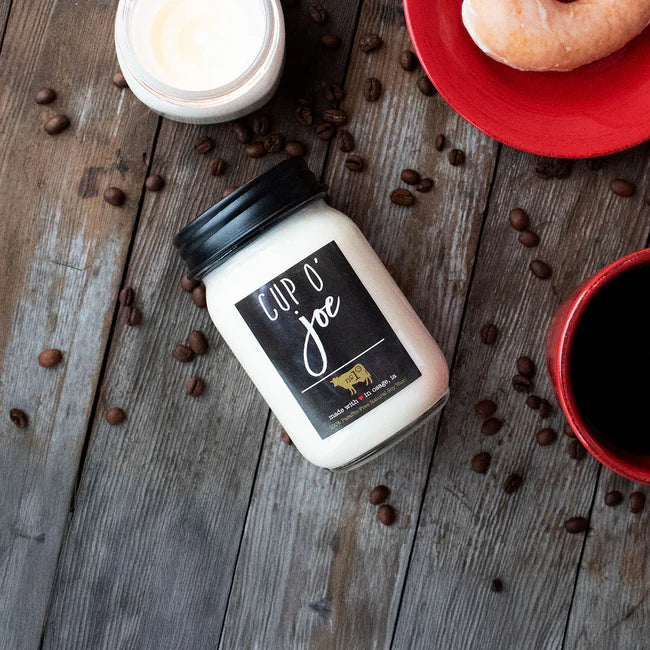 Jar of 'Cup O' Joe' on a wooden surface with coffee beans and a cup of coffee.