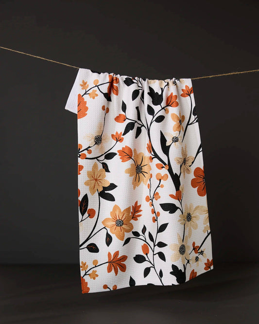 Geometry kitchen tea towel with floral patterned towel hanging on a line against a dark background