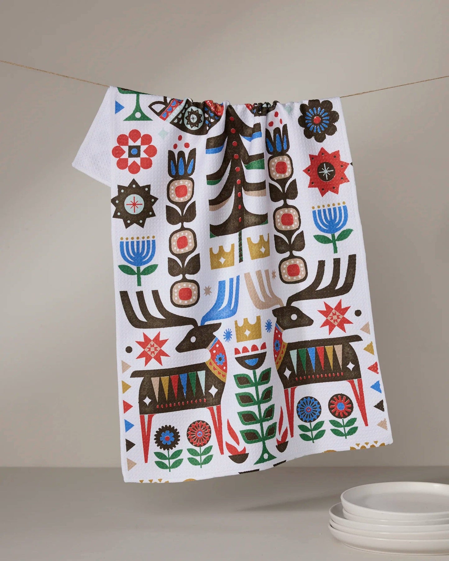 Geometry Tea Towel Everfolk Decorative towel with colorful patterns hanging on a line against a neutral background.