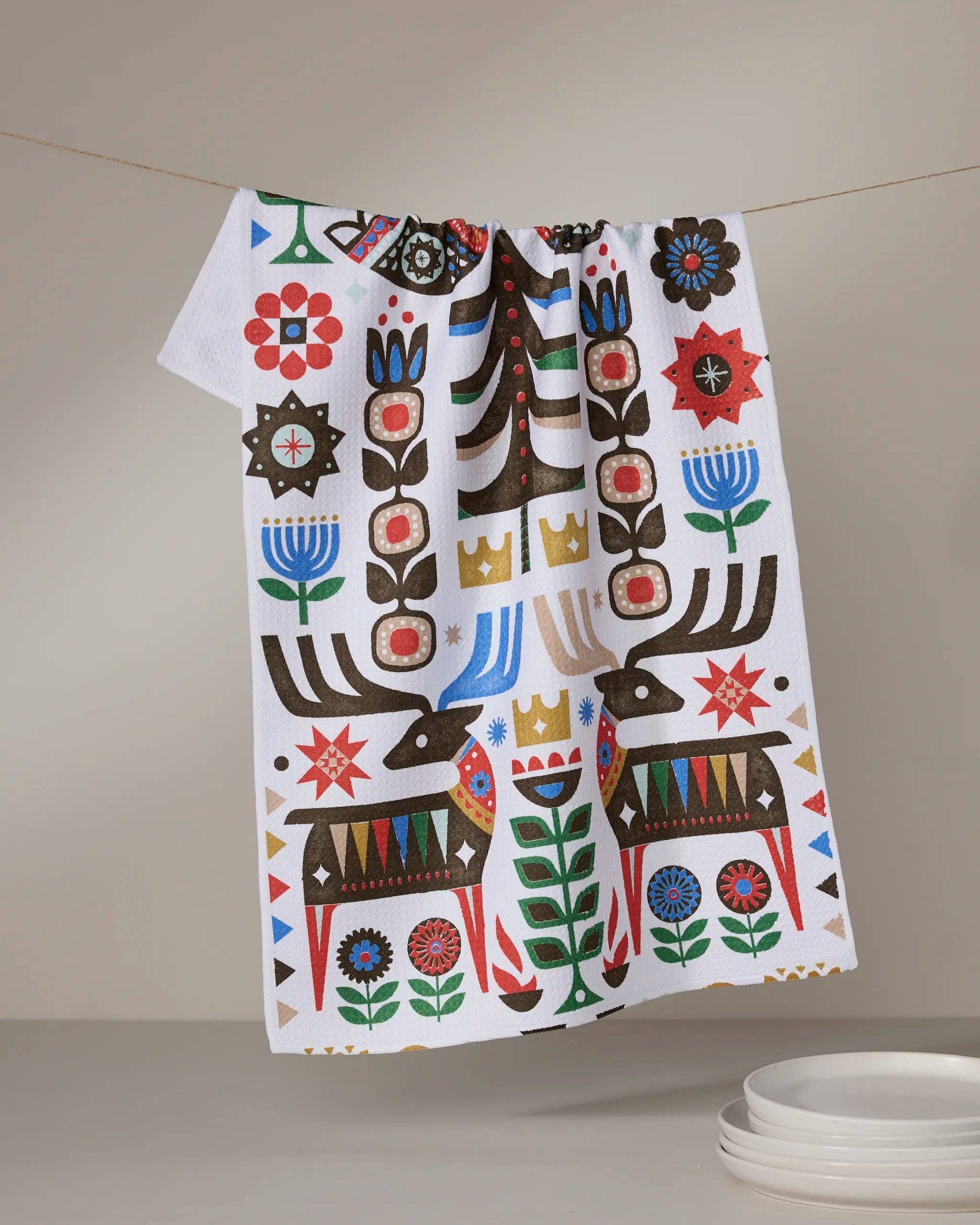 Geometry Tea Towel Everfolk Decorative towel with colorful patterns hanging on a line against a neutral background.