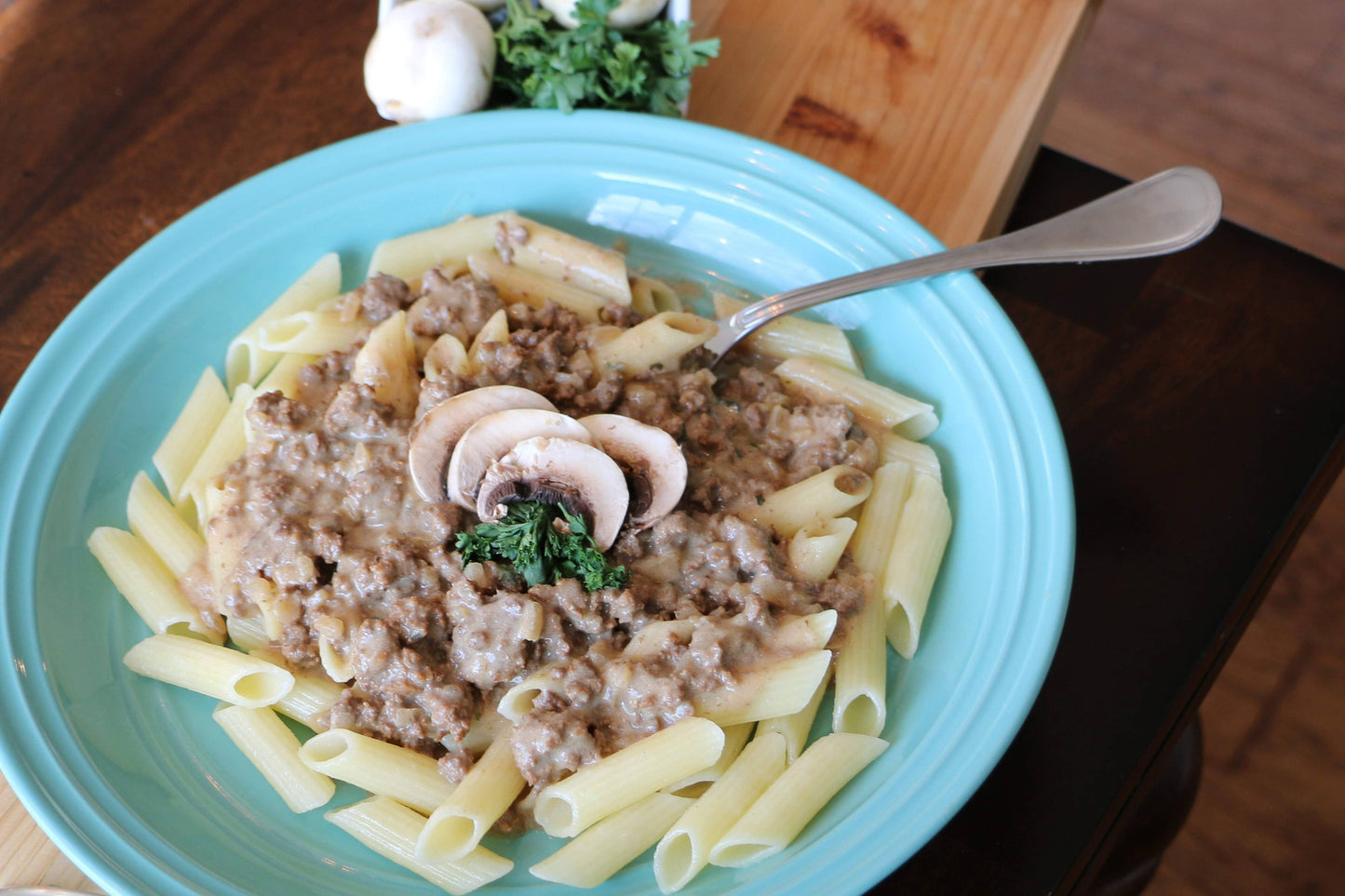 Pasta dish with meat sauce and mushrooms on a blue plate