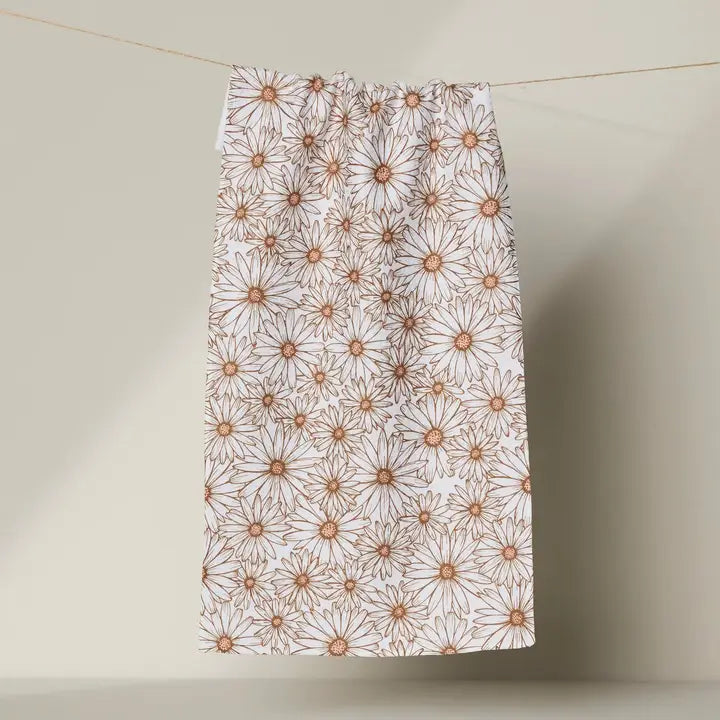 Floral patterned Geometry bar towel hanging on a line against a neutral background