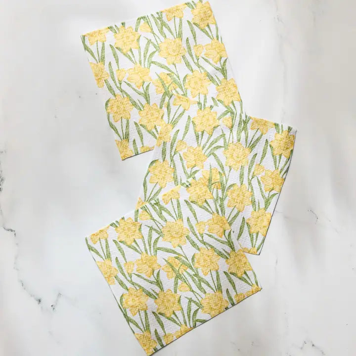Three Geometry dish cloth towels with yellow floral pattern on a marble surface