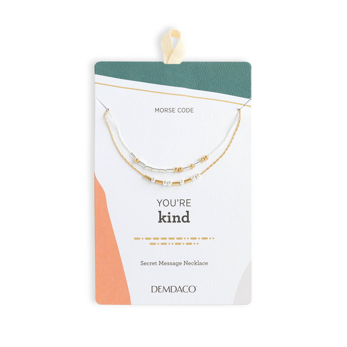 A double-strand gold and white beaded necklace with a Morse code message, presented on a white card with a teal and peach geometric design. The card is labeled 'MORSE CODE', 'YOU'RE kind', and 'DEMDACO'.