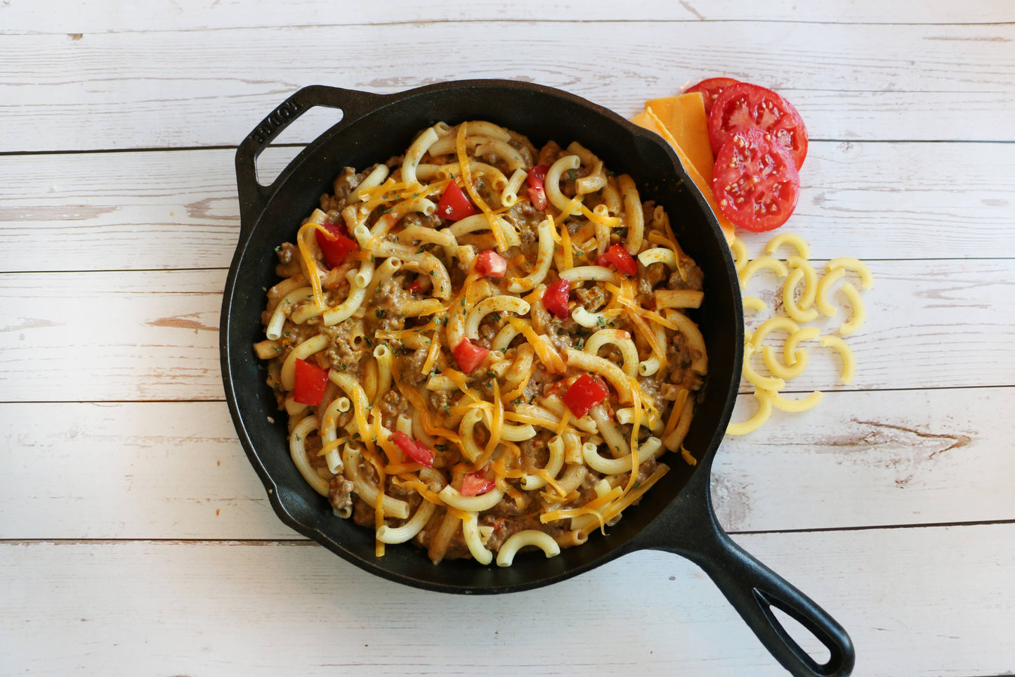 Skillet with pasta dish on a wooden surface