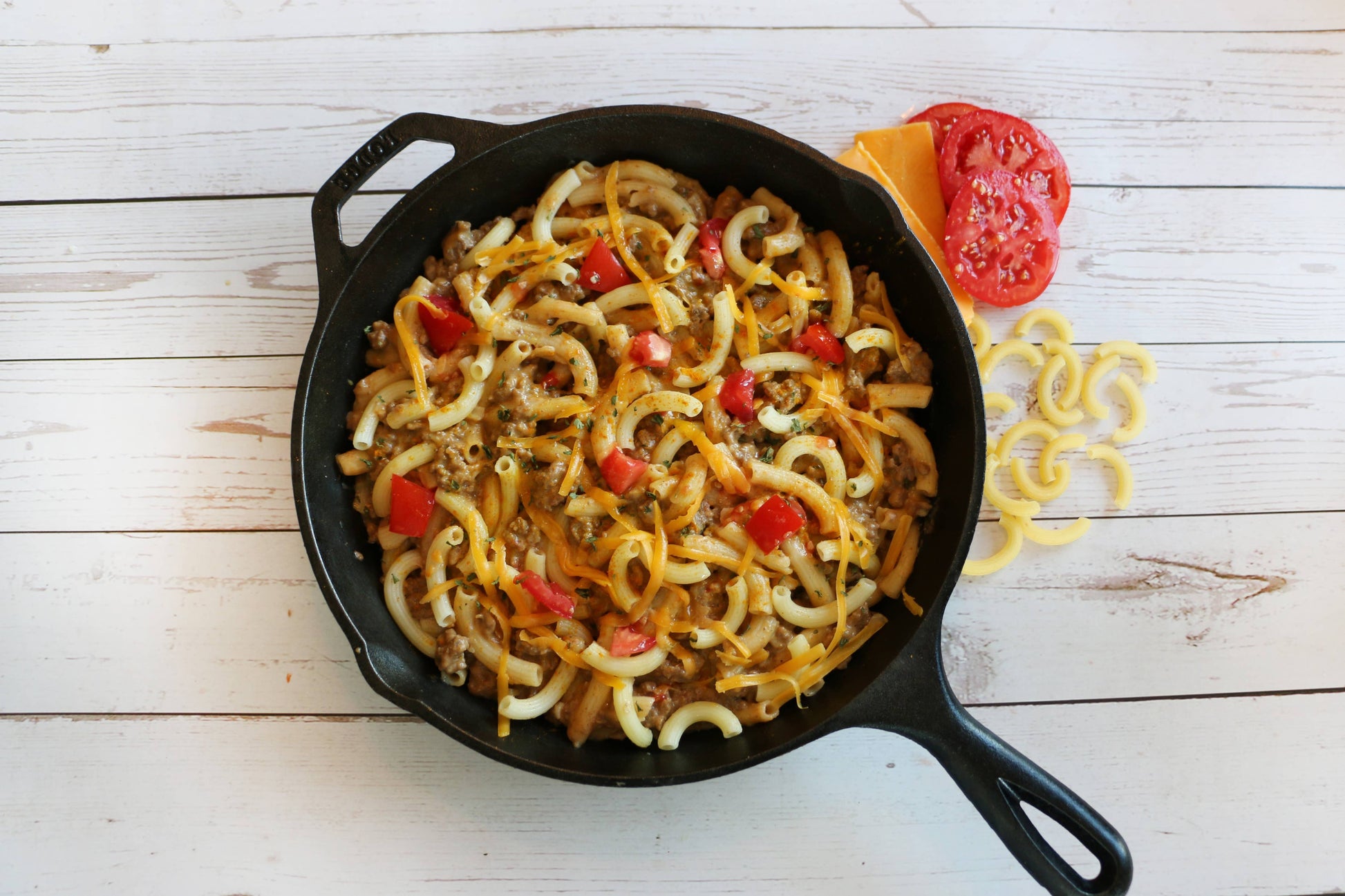 Skillet with pasta dish on a wooden surface