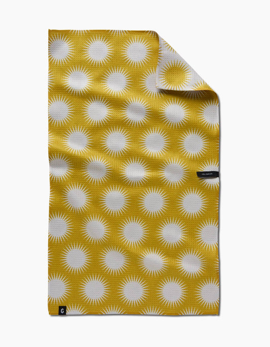 Yellow towel with white sunburst pattern on a white background