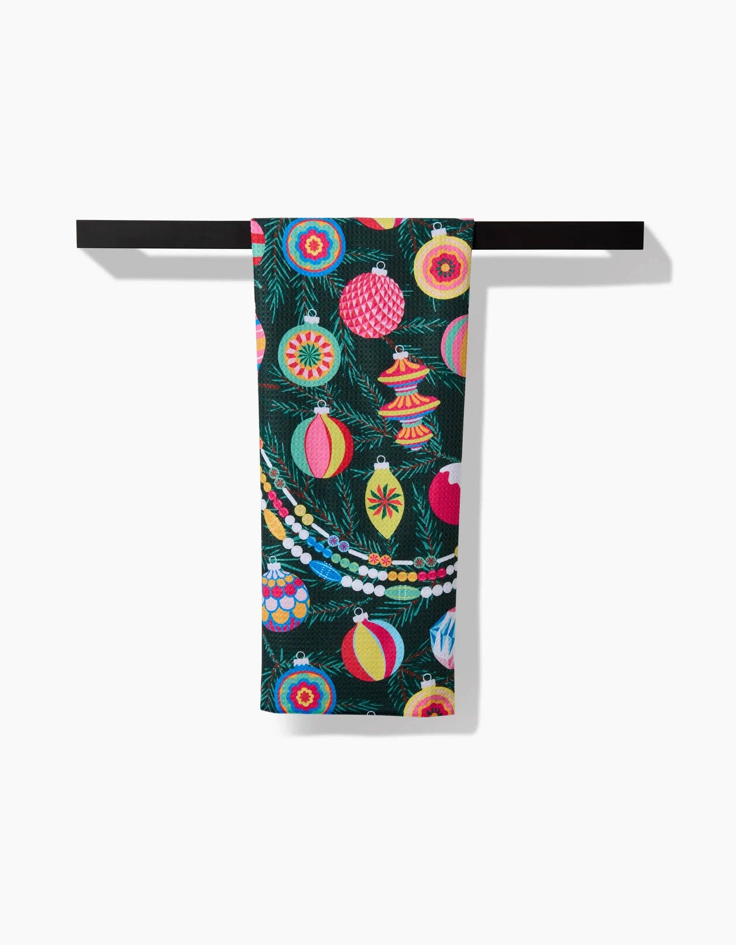 Geometry Tea Towel Colorful towel with Christmas ornament design hanging on a rack against a white background