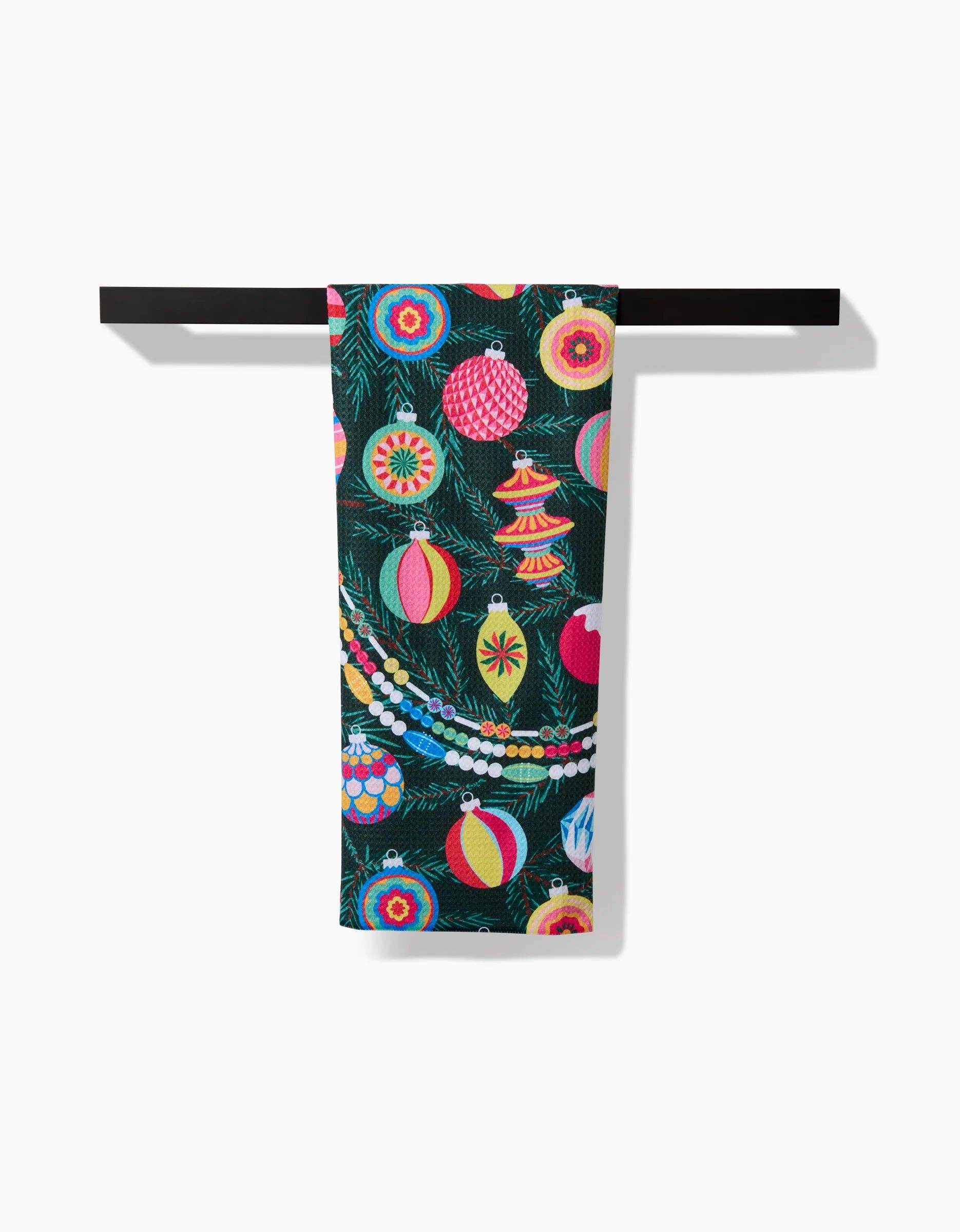 Geometry Tea Towel Colorful towel with Christmas ornament design hanging on a rack against a white background