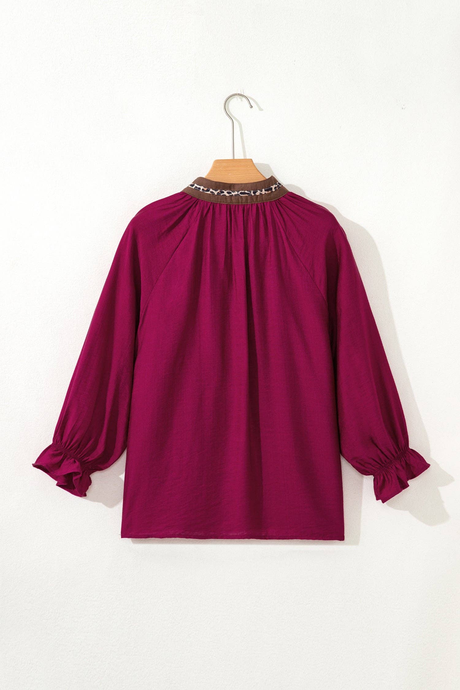 Purple blouse on a hanger against a white background