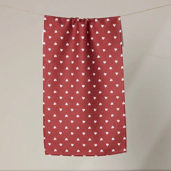 Geometry bar towel with white heart pattern hanging on a line against a plain background
