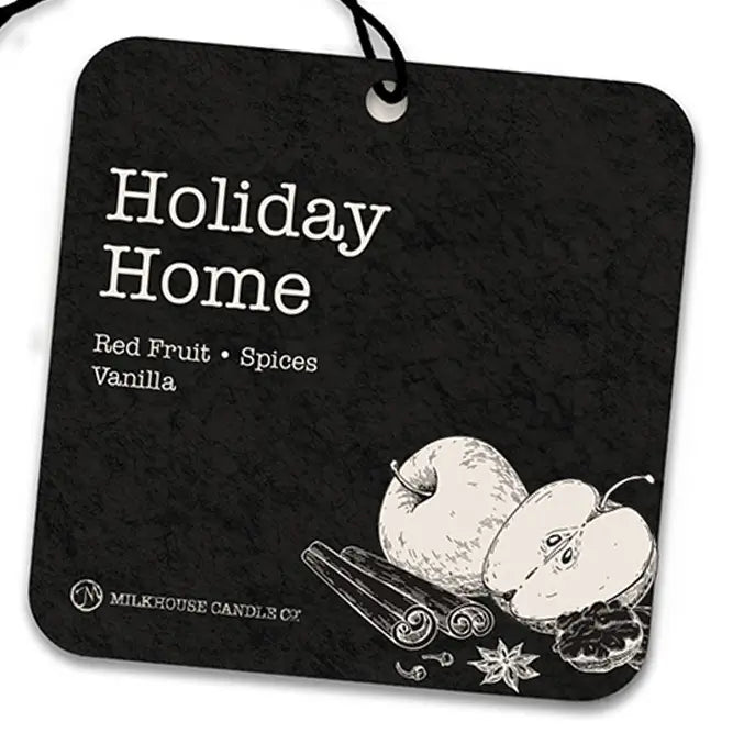 A square black air freshner with rounded corners, hanging from a black string. White text reads 'Holiday Home' and 'Red Fruit • Spices • Vanilla,' with a white line drawing of apples, cinnamon sticks, and spices at the bottom.