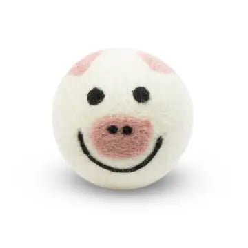 White wool dryer ball with a smiley face of a pig design on a white background