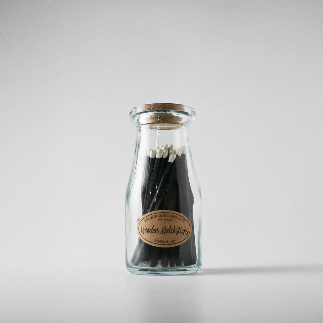 Glass bottle with wooden matches on a white background