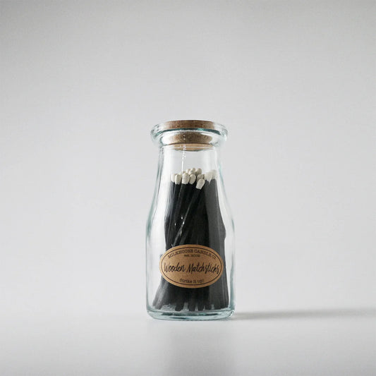 Glass bottle with wooden matches on a white background