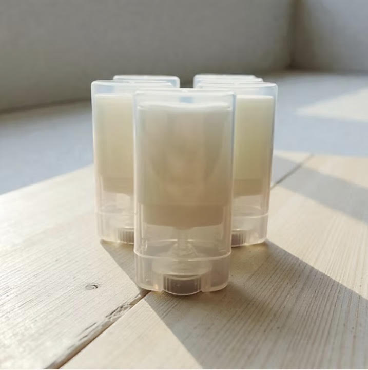 clear plastic containers with Pure Face Sun Protectant substance on a wooden surface