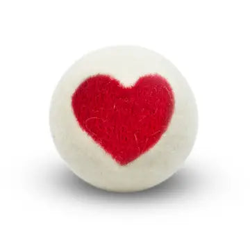 White wool dryer ball with a red heart design on a white background