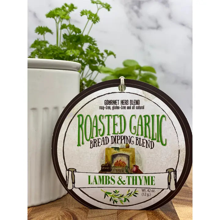 Roasted Garlic Bread Dipping Blend label with a wooden background with herbs from Lambs & Thyme