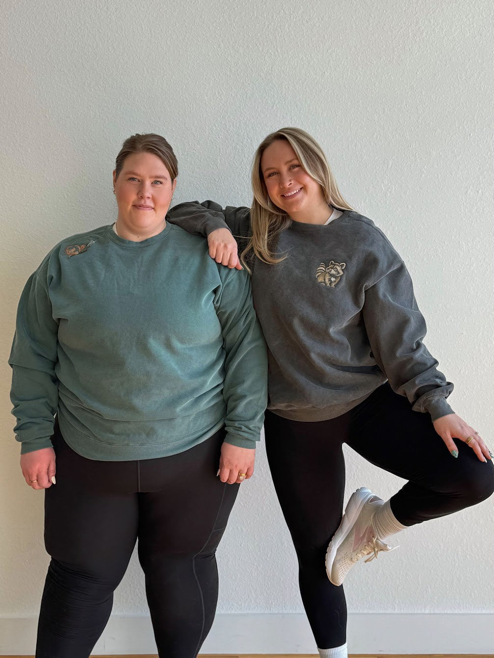 Ladies in black leggings with embroidered crewneck sweatshirts on white background