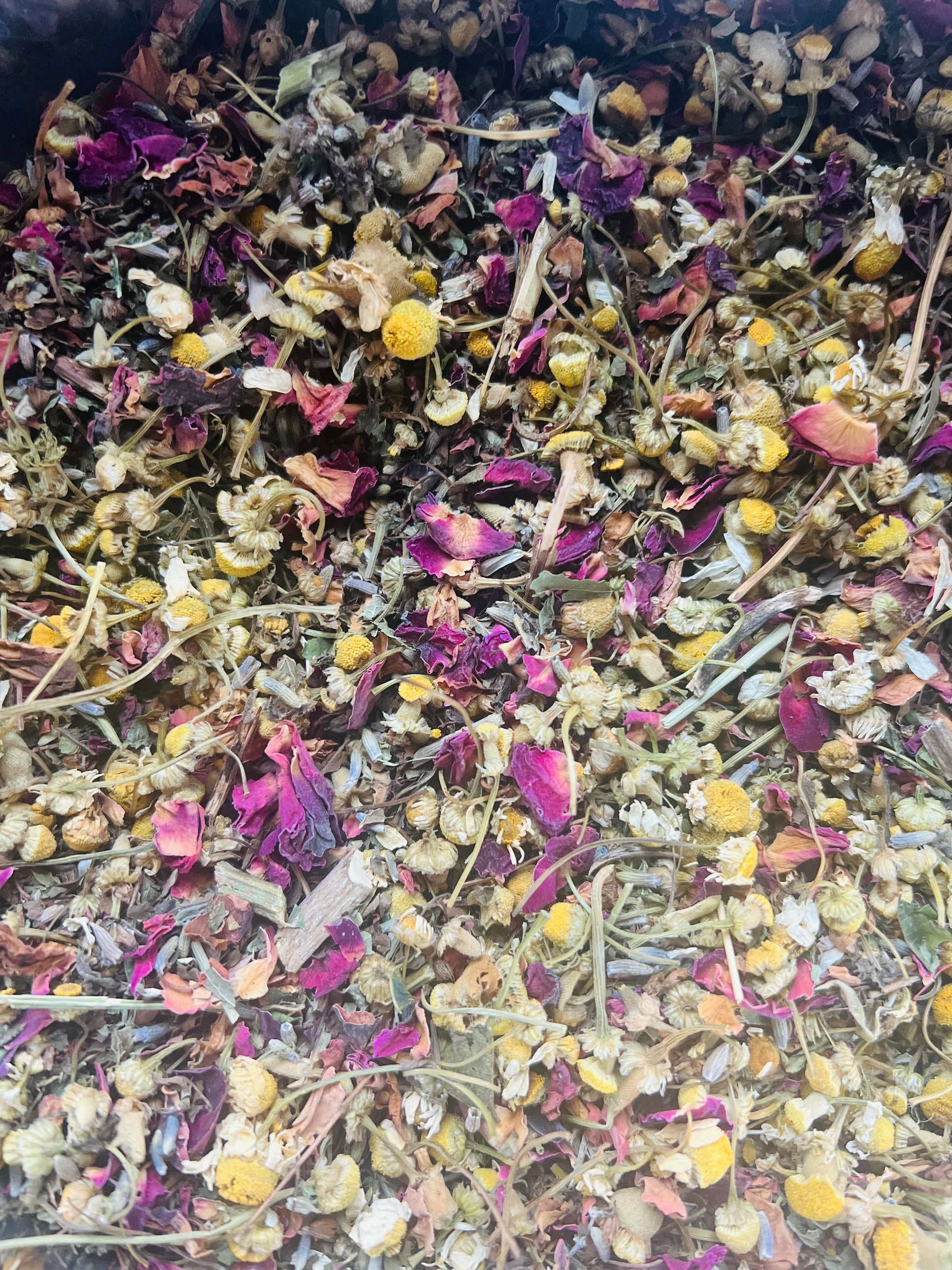 Mixture of dried flowers and herbs with various colors including purple, yellow, and green.